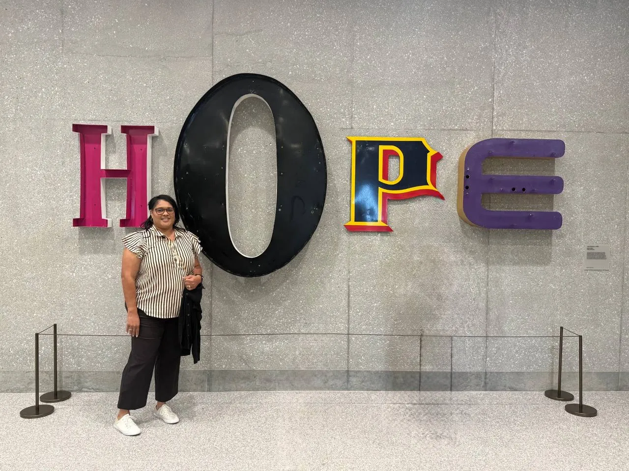 Mrs. B beneath a giant HOPE sign